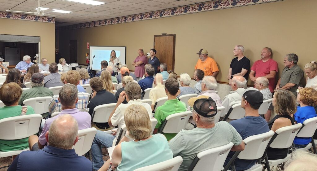 Marla Korpar of solar power company Orsted speaks in front of a packed crowd at the Deerfield Township Hall on Aug. 13. (Photo by Erik Gable)
