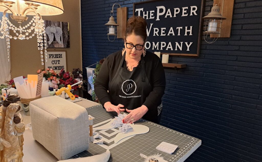 Tabitha Turnbow, founder of The Paper Wreath Co., works on a piece at her Adrian home.  (Photo by Arlene Bachanov)