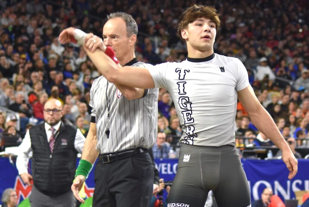 Hudson’s Nicholas Sorrow stands with his hand raised in victory on March 7 at Ford Field. (Photo courtesy of MHSAA)