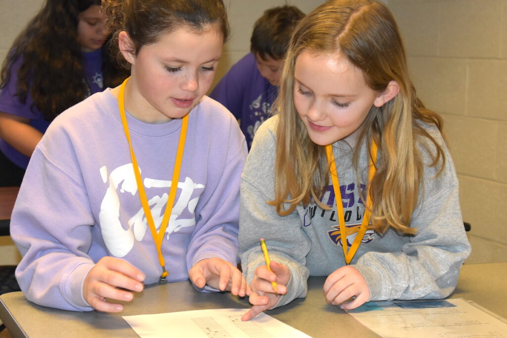 Onsted third-graders Amelia Moore and Elizabeth Symington work on one of the exercises at the 2026 Tri-County Science Olympiad.