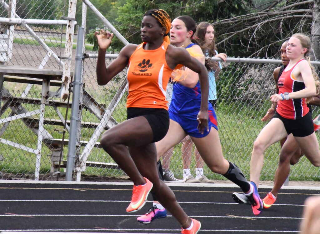 Naika Rath from Hudson leads Gigi Masters from Lenawee Christian in the girls 100-meter dash.