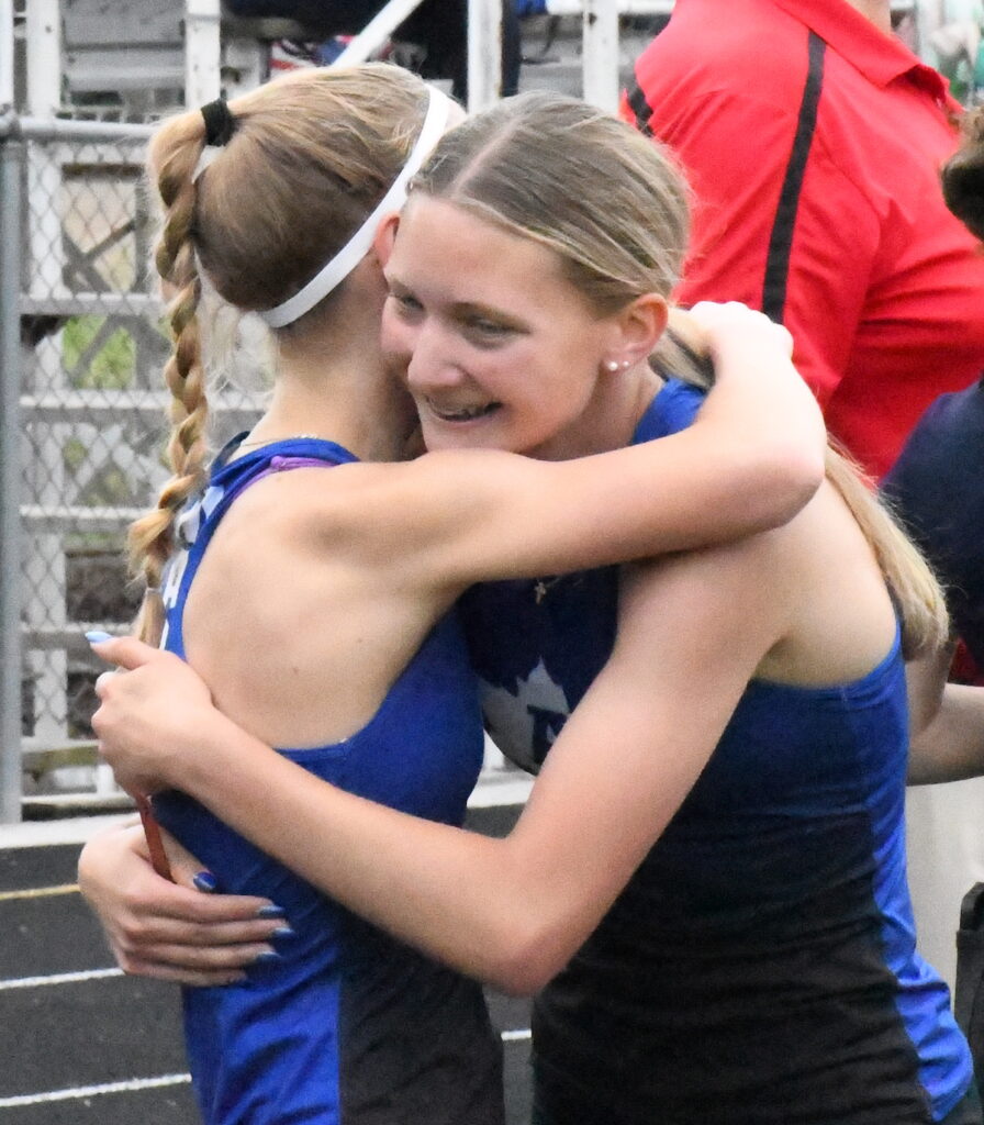 Adrian’s Ayda Skeels and Madison Petty celebrate after Skeels’ win in the 800-meter event at the county meet on May 26.