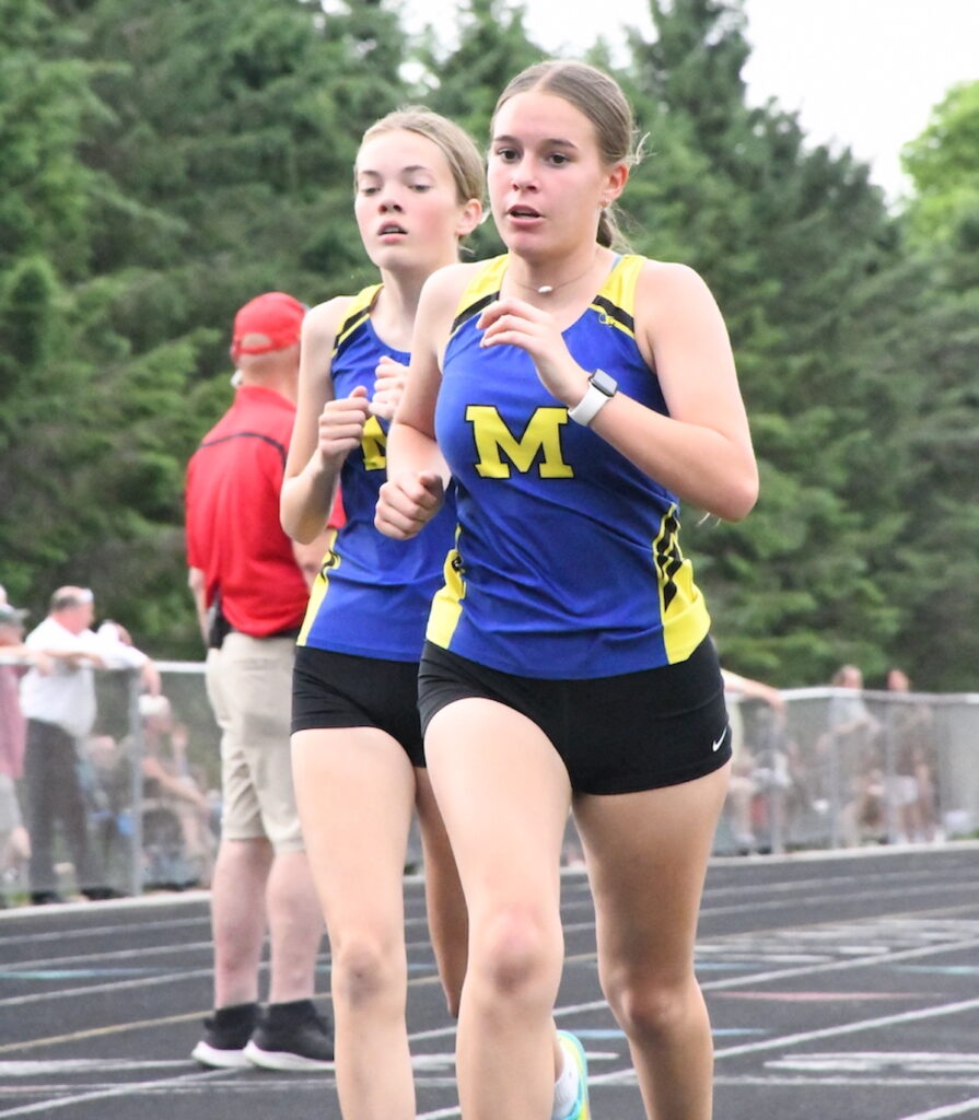 Madison’s Juliana Leonard and Haleigh Summers run in the girls 1,600-meter event at the Lenawee County track and field meet on May 26.