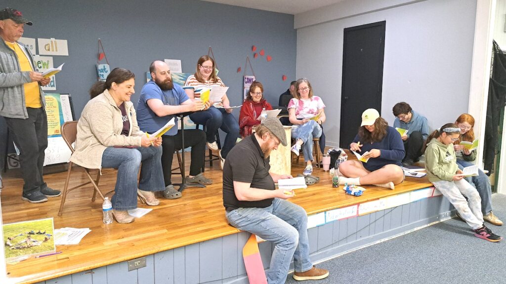Cast members in the Tecumseh Players’ upcoming performance of “Head Elf” rehearse the show recently at the Tecumseh Presbyterian Church. Seated on the edge of the stage, left to right: Thomas Buxton, Annabelle Rhodes, and Charlotte Buxton. Behind them, left to right: Derrell Kent, Mary Ann Stock, Nick Hoffman, director Sarah Buxton, Brandi Williams, Josh Smith, Niki Easter, Hannah Wiles, and Henry Buxton. (Photo by Arlene Bachanov)