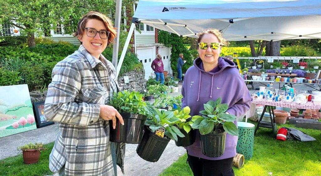 Christy Mesaros-Winckles and Kellie Zwolinski work at the Adrian Garden Club’s annual plant sale in May. The club is celebrating 100 years in existence this year. (Photo by Julie C. Clemes)