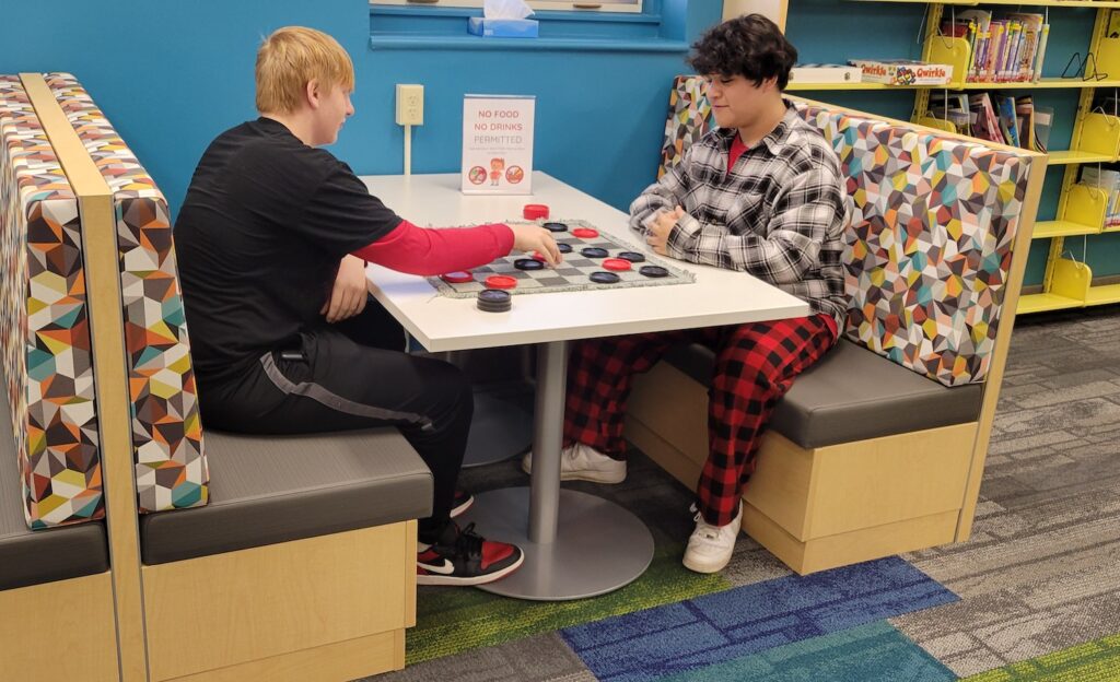 Dominic Bryan, 14, and Luciano Sanchez, 15, converse over a game in the Adrian District Library youth services department.