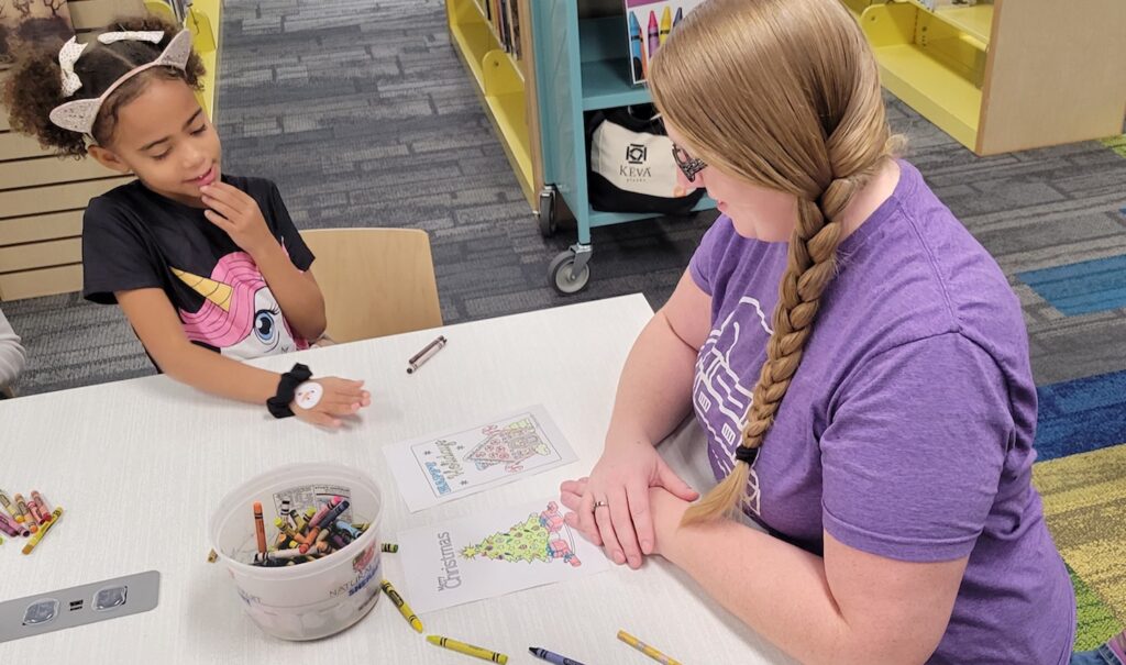 Naomi Mitchell, 6, of Adrian and her mom, Brittany Cole, work on a coloring project in the new Adrian District Library youth services department.