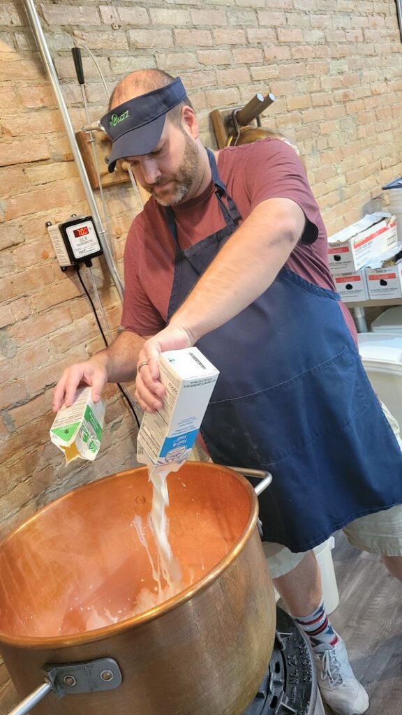 Ben Rosebrock pours half-and-half into a copper kettle while demonstrating how to make fudge during a class at The Buzz in downtown Adrian.