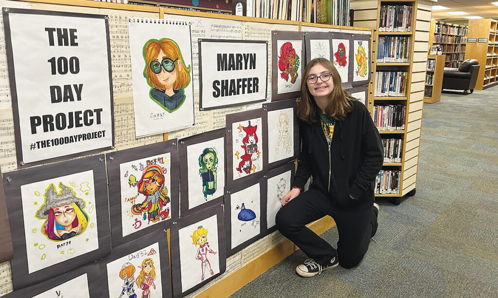 Maryn Shaffer, now a sixth grader, took part in all 100 days of the 100 Day Project last year, creating 100 drawings that were displayed in the Stair District Library community room. She’s pictured here with a selection of those drawings, which are currently in the library entryway.