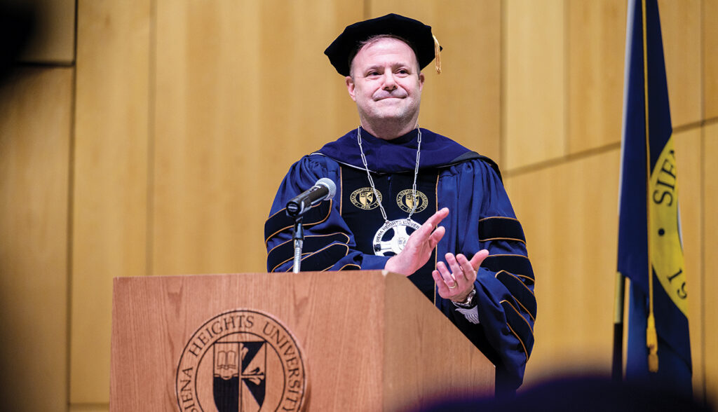 Douglas Palmer, the 11th president of Siena Heights University, applauds the assembled students, faculty, staff and supporters of the university at his inauguration on March 15 at the Mary and Sash Spencer Performing Arts Center. (Photo by Laura Harvey/Siena Heights University)