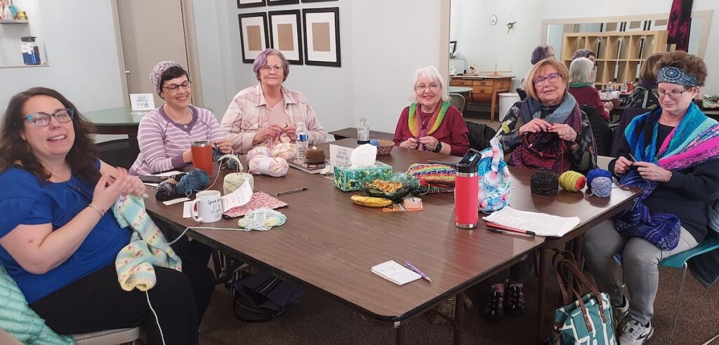 Michelle Beechler, Suzanne Helfer, Chris Maldonado, Thea Chambers, Jan Parson and Margaret St. John are pictured during a Social Stitching meetup at Tink and the Frog, a downtown Adrian needlework shop.