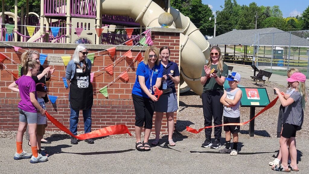 Lisa Eack of the Lenawee Great Start Collaborative cuts the ribbon for the Wakefield Park story walk, the first of four to be installed in Lenawee County.