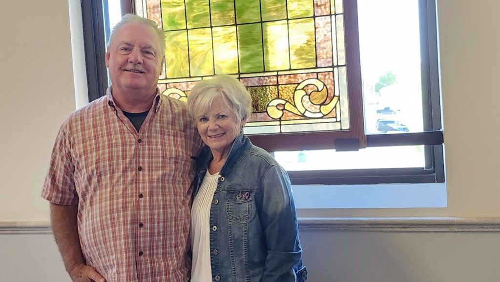 Mark and Mary Murray are pictured inside the Adrian Armory Events Center. In addition to its own heritage, the building contains echoes of other local landmarks — such as this stained glass window, which was once part of the old Adrian High School.