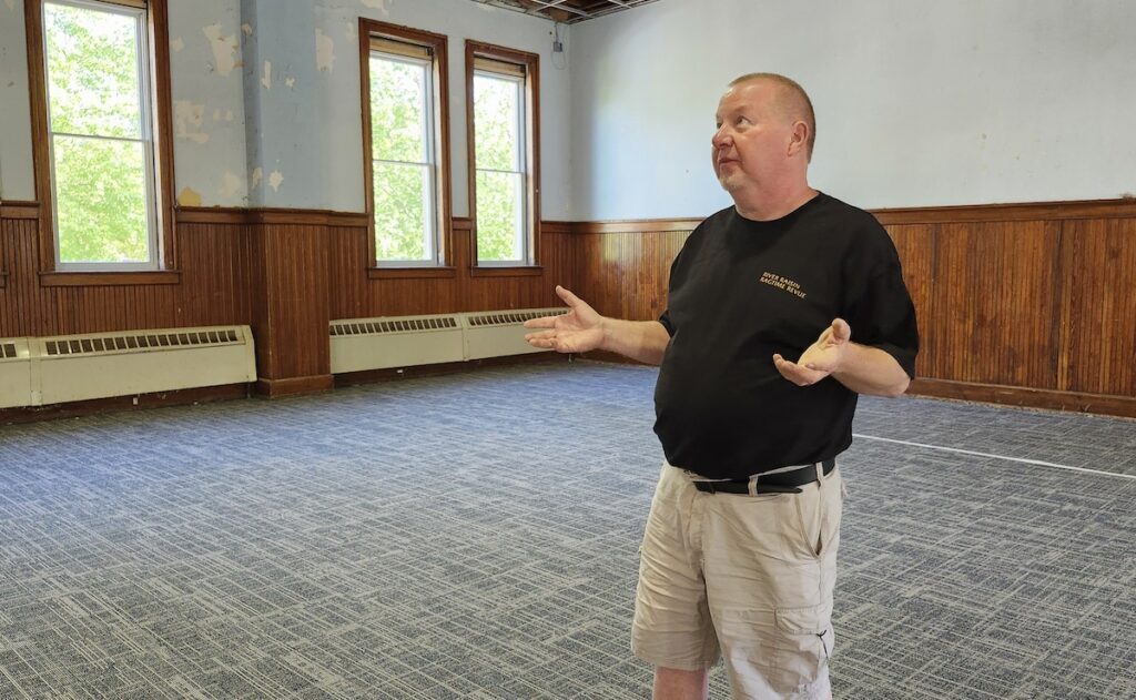 William Pemberton shows the inside of the former Adrian Training School chapel and activities center, which has been named Haviland Hall and is being renovated into a performance space for the River Raisin Ragtime Revue.