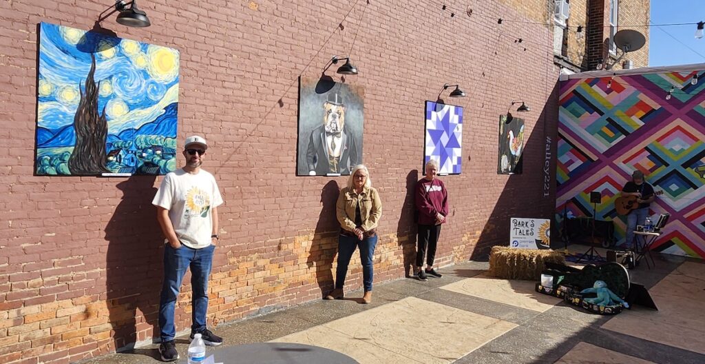 Artists involved in the current display at Alley 221 in Morenci take part in the semiannual unveiling of new artwork for the parklet at Morenci’s Fall Fest.