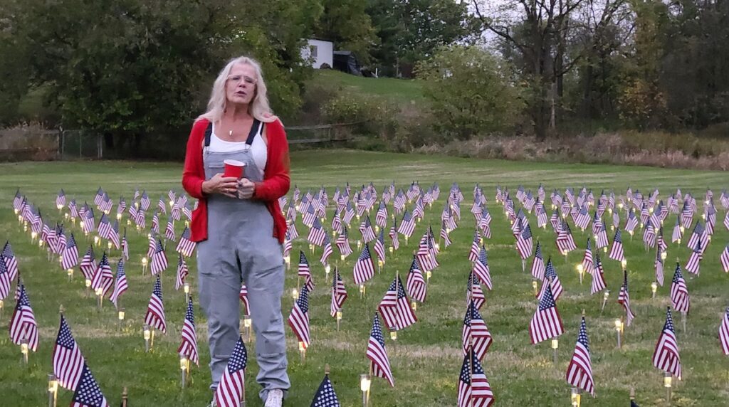 Erika Behm speaks at the retirement of 660 flags that were placed in Clayton’s village park throughout September. The flags, 22 of which were placed every day, represent veterans who have been lost to suicide.