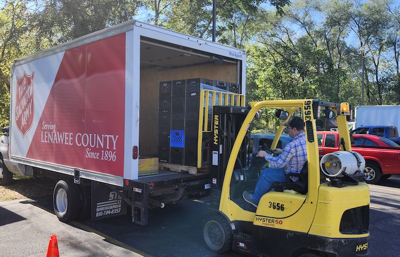 Marty Nichols loads empty crates onto the Salvation Army’s new truck in preparation for a food pickup run.