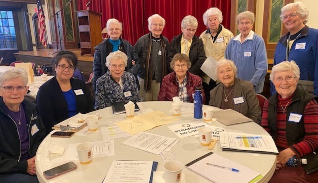 Sentados, de la izquierda a la derecha: Patricia Leonard, Laura Negron-Terrones, Attracta Kelly, Dorothy Dempsey, June Racicot, y Beverly Stark. De pie, de la izquierda a la derecha: Virginia “Ginny” King, JoAnne Fleischaker, Joanne Peters, Joyce Caulfield, Carleen Maly, y Sharon Weber.