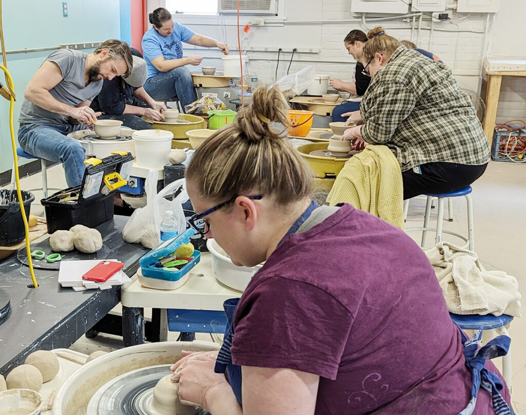 Students work on the potters’ wheels during a ceramics class at the Adrian Center for the Arts in Adrian.