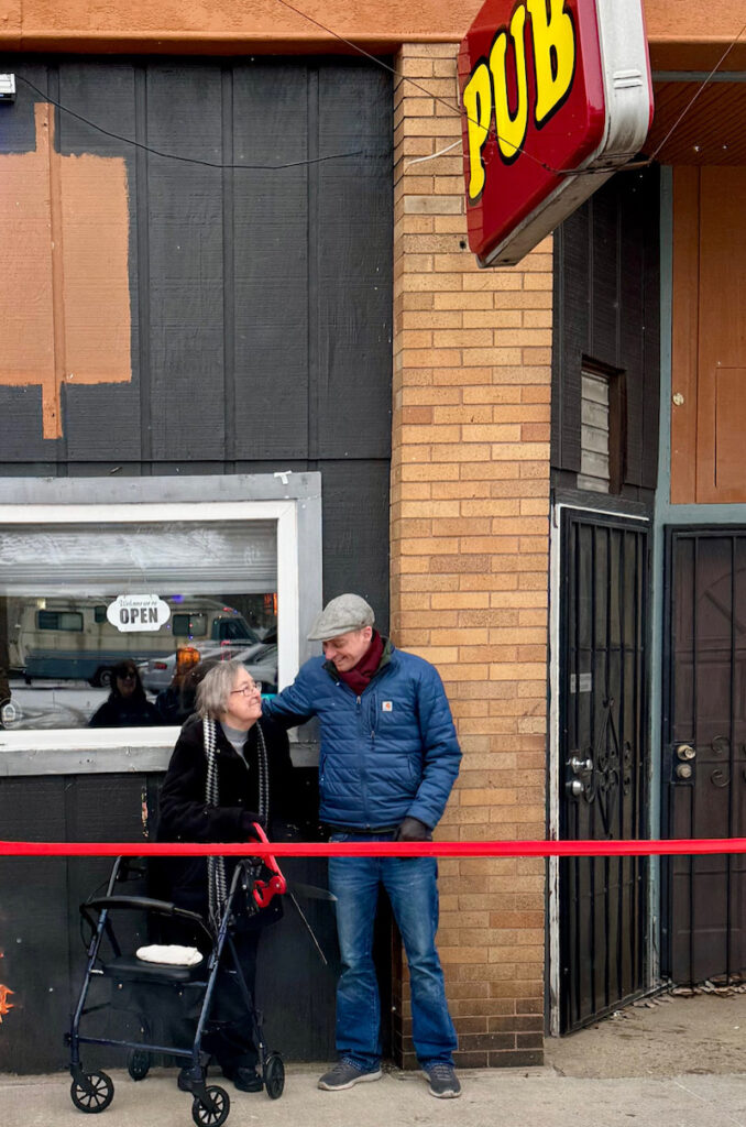 A Jan. 4 ribbon cutting at the North Street Pub in Morenci was a family affair, with many of owner Tony Muzzi's relatives traveling to Morenci to attend. Here, Muzzi's grandmother, Bernie Ickes, prepares to cut the ribbon.