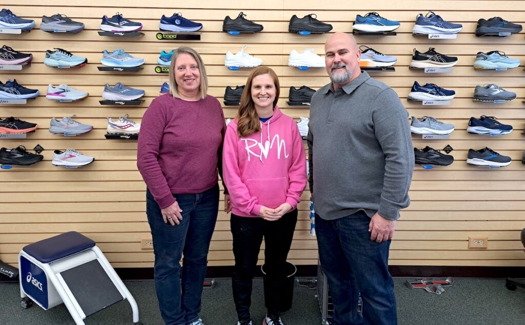 Rachel Miller, center, pictured with Kerri and Eric Clarke, is the new owner of Running With E’s in downtown Adrian. Miller first started shopping at the store when she was a middle school runner at Hudson. (Photo by Arlene Bachanov)