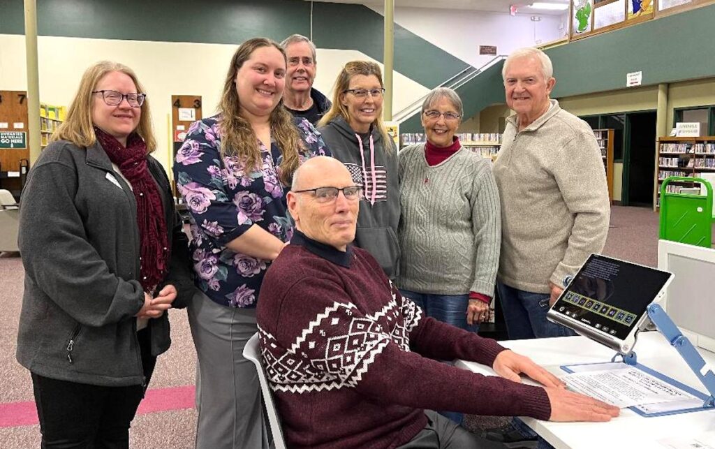 Standing, from left to right: Jennifer Wrzesinski, Adrian District Library director; Chelsey Boss, assistant director; and Lions Club members Robert Guy, Laura VanSickle, Charlene Dickerson, and Larry Atkin. Seated: Lions Club member Paul Williams.