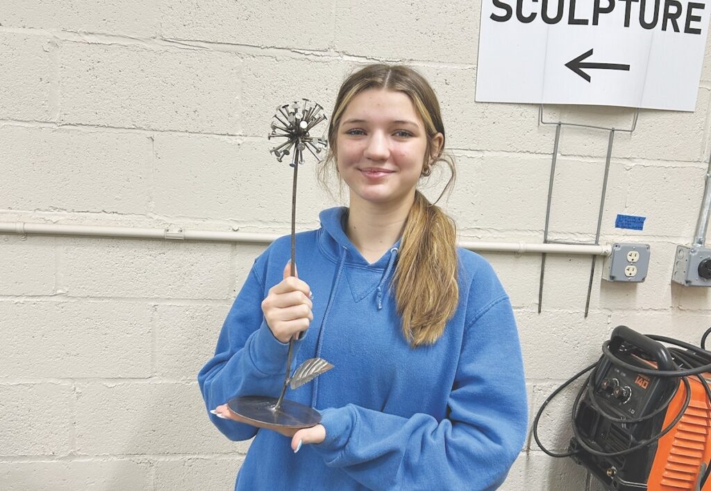 Josephine Eva Maurer shows a piece she made in the Adrian Center for the Arts’ new welding program.