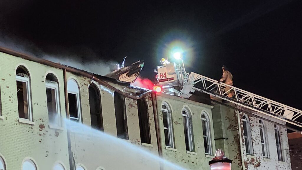 A crew from the Morenci Fire Department works on the roof of one of the involved buildings shortly before 8:45 p.m.