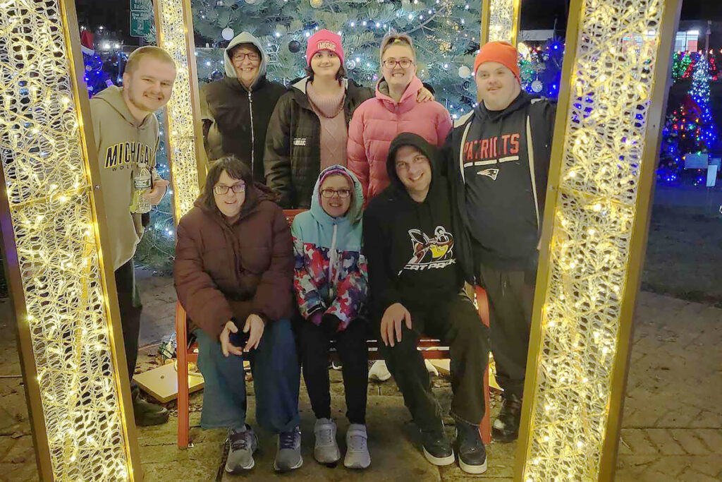 Pictured during a HOPE Center outing to the Comstock Christmas Riverwalk in Adrian are, standing, Jordan Cutler of Adrian, Tracy Huston of Adrian, Sara Ann Stock of Adrian, Paiton Smith of Adrian, and Nick Merrill of Addison; and seated, Sarah Feeney of Adrian, Sammi Wood of Tecumseh, and Buddy Hale of Adrian. (Photo courtesy of the HOPE Center)