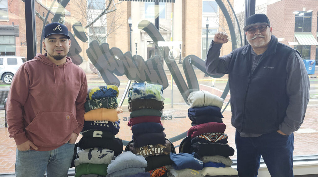 Vince Inclan and Pete Vargas show some of the hoodies and sweatshirts that have been collected for Lenawee County's migrant farmworkers.