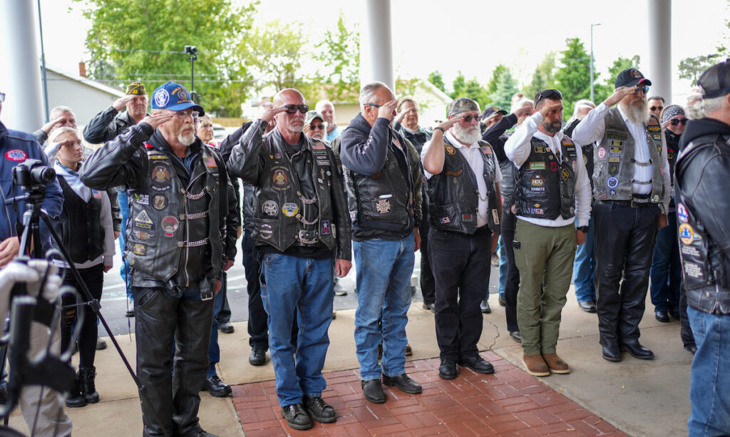 Members of the American Legion Riders salute as Staff Sgt. Ralph Mourer is carried from Wagley Funeral Home to begin a procession to Oakwood Cemetery. (Photo by Lad Strayer)
