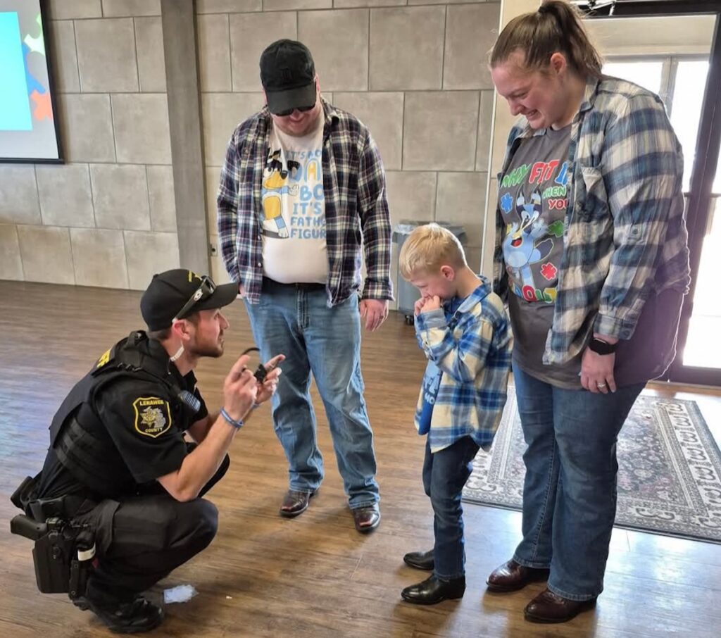 Deputy Cody Bowman of the Lenawee County Sheriff’s Department talks with Wyatt Brooks during a March 9 Cookies with Cops event while parents Kyle and Cynthia Brooks look on. The event was organized by Autism GRACE of Lenawee and took place at The Ashlar in Tecumseh.