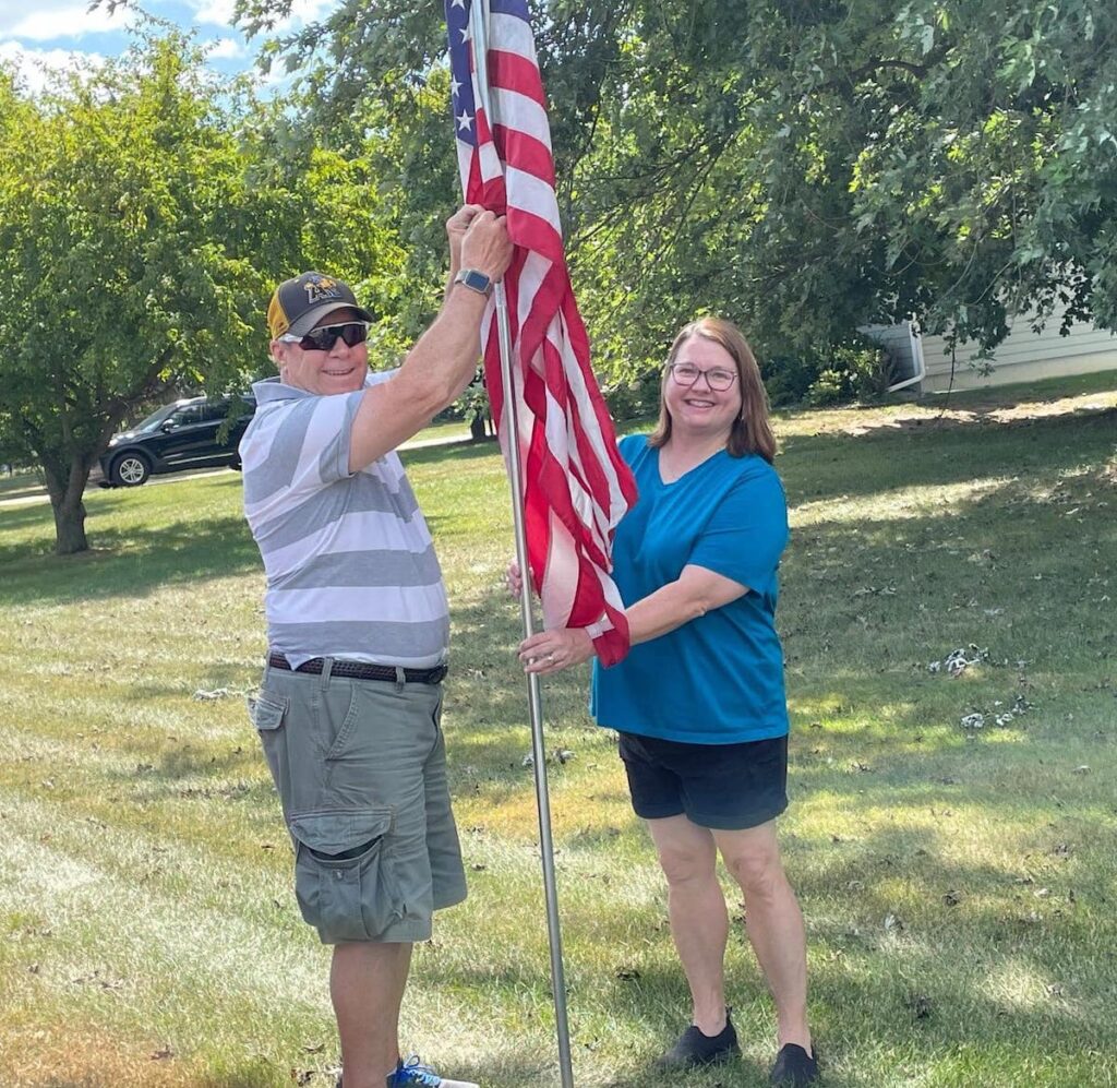 Bryan Reeder and Paula Trentman plant a flag just before Memorial Day 2024, at the beginning of the Kiwanis Club flag season.