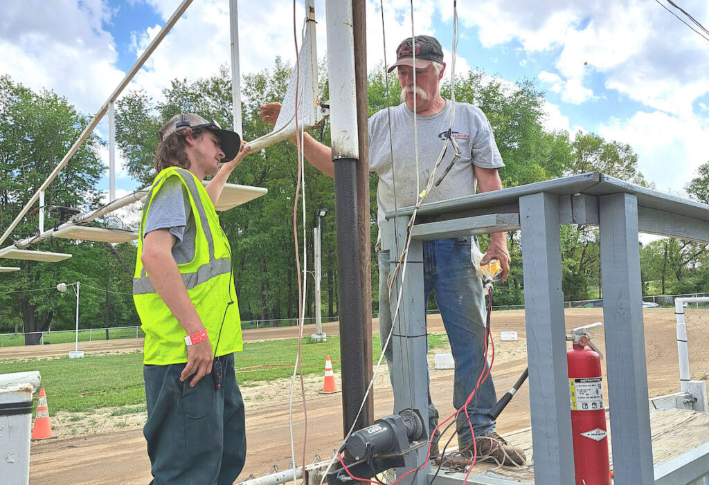 Palmyra Speedway owner John Bailey, right, and his assistant, Matthew Cox, prepare the electronic scoring system for the evening’s competition. (Photo by Arlene Bachanov)