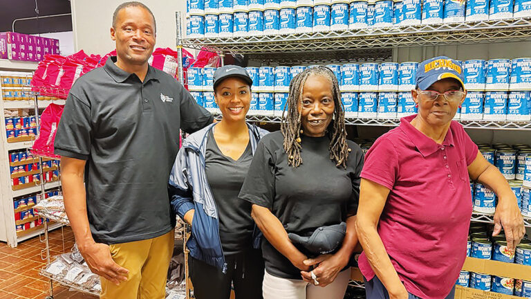 De’Angelo Boone, founder of the City of Refuge Ministries Meal Assistance Program, stands with volunteer Genesis Hardnett, manager Rosemary Hardnett, and volunteer Teresa Cash in the food pantry’s Tecumseh facility. (Photo by Renee Lapham Collins)