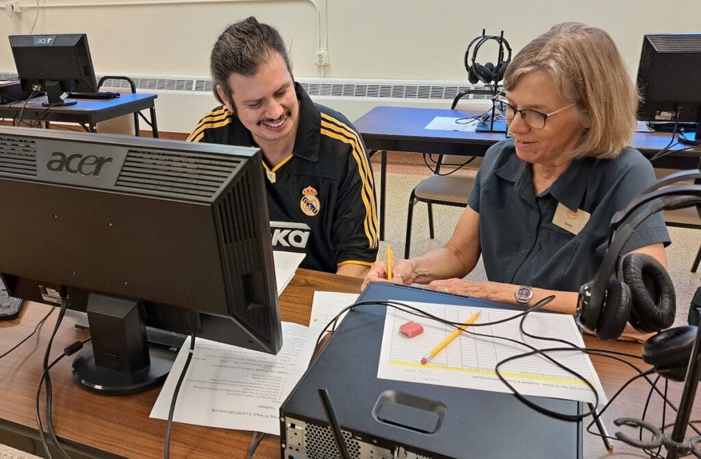 César Del Campo-Hernández works with staff member Doris DeNudt at the Adrian Rea Literacy Center. The center was opened by the Adrian Dominican Sisters in 2008 and serves both English language learners and native speakers who need to learn reading and writing. (Photo by Arlene Bachanov)