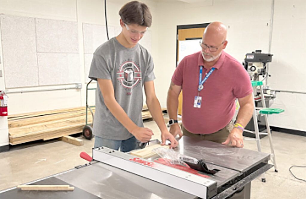 Student Thomas Darr works with teacher Tony Aiken in Adrian High School’s Industrial Arts class. (Photo courtesy of Adrian Public Schools)