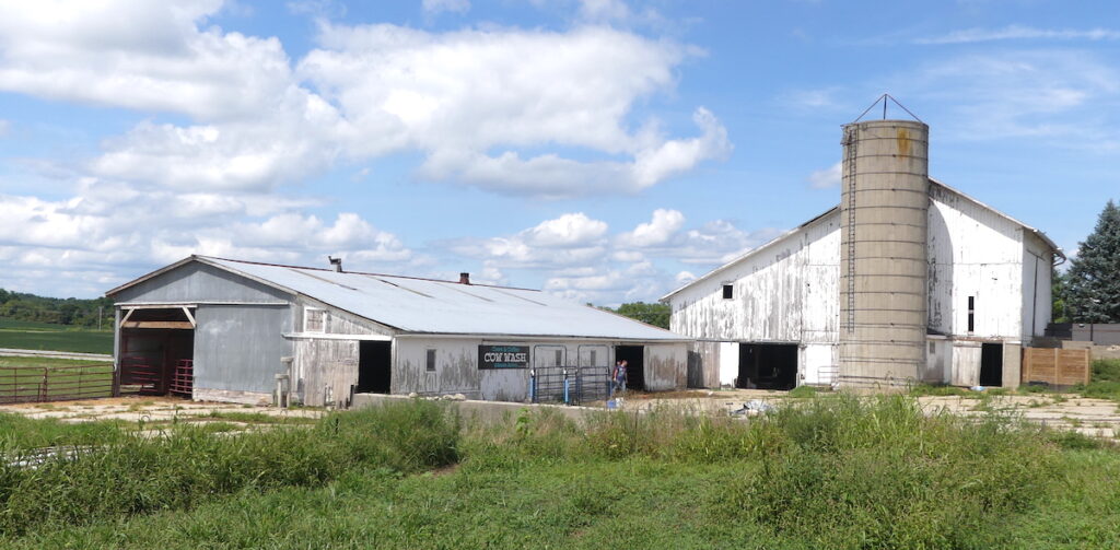 Old farm buildings at Asam Acres now hold community-friendly signs like “Cow Wash.” (Photo by Kadi Franson)