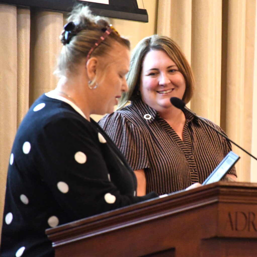 Sara Herriman listens as Kasey White introduces her to speak about the Boys & Girls Club of Lenawee.