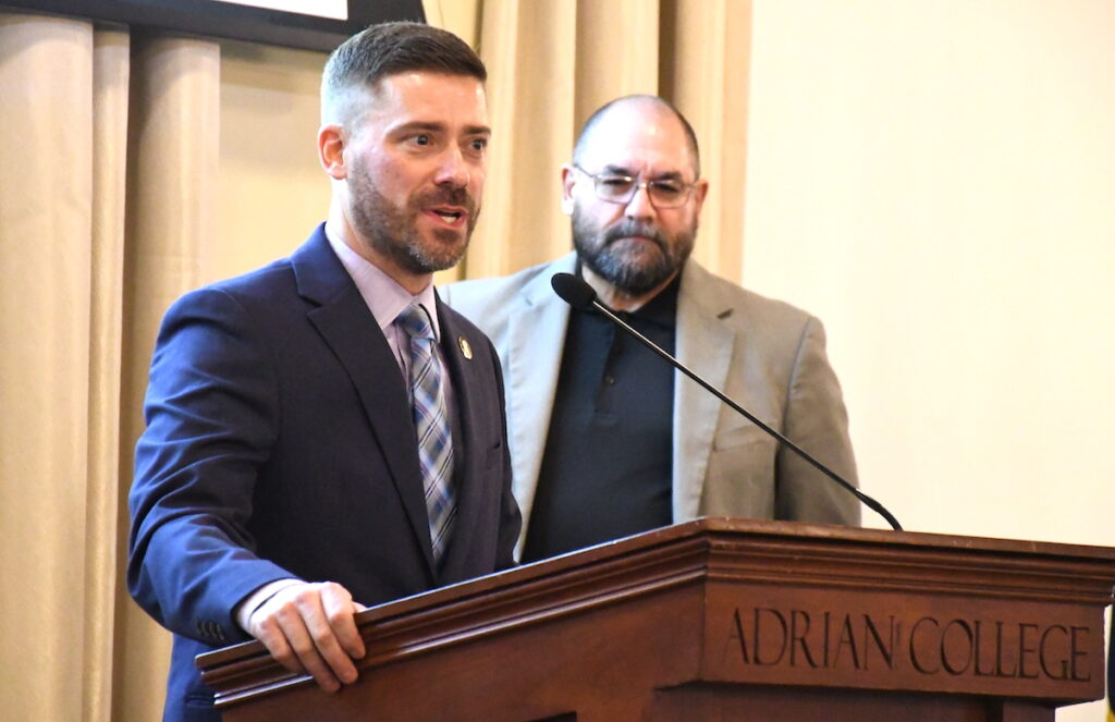 Adrian police chief Vince Emrick accepts the Lenawee NAACP's Police Office of the Year Award while Joe Costello looks on.