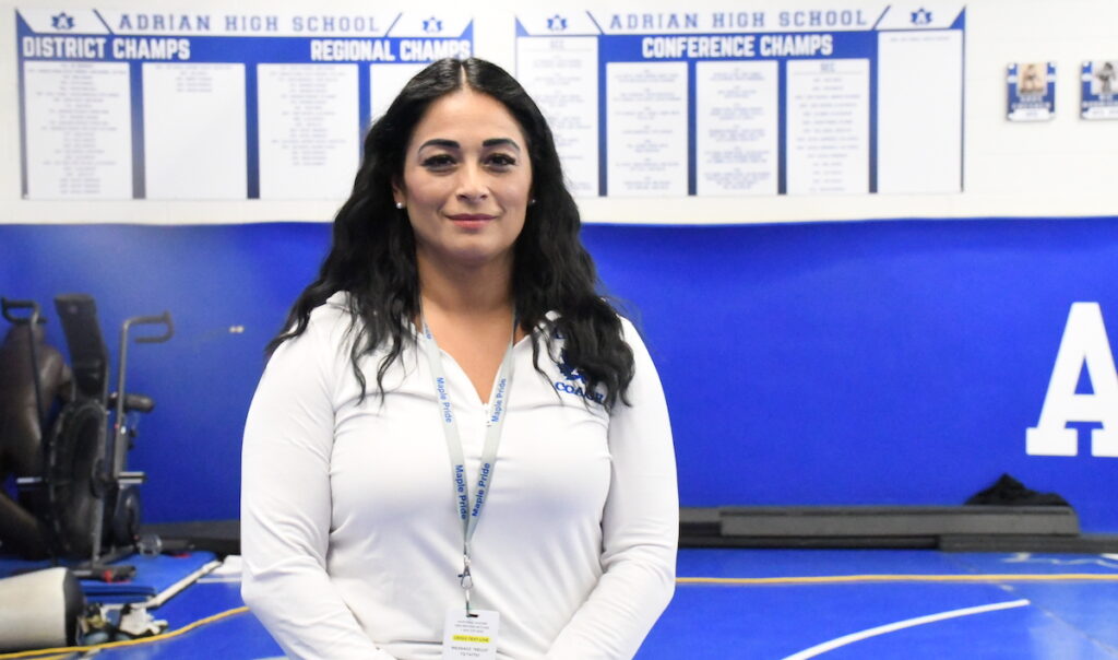 Natasha Taylor is pictured in front of a display in the Adrian High School wrestling room that includes the name of her father, Refugio Rodriguez Jr.