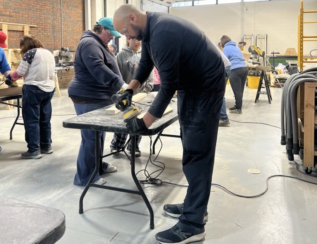 Chris Howard of the Lenawee Intermediate School District works on a bed during a build event at the LISD Tech Center for Sleep in Heavenly Peace. (Photo courtesy of the LISD)