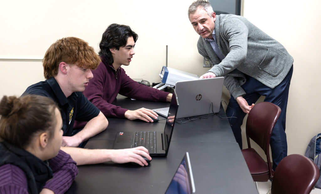 Adrian College adjunct professor Jamie Davis answers a question from student John Lloyd during a mechanical engineering class. (Photo courtesy of Adrian College)