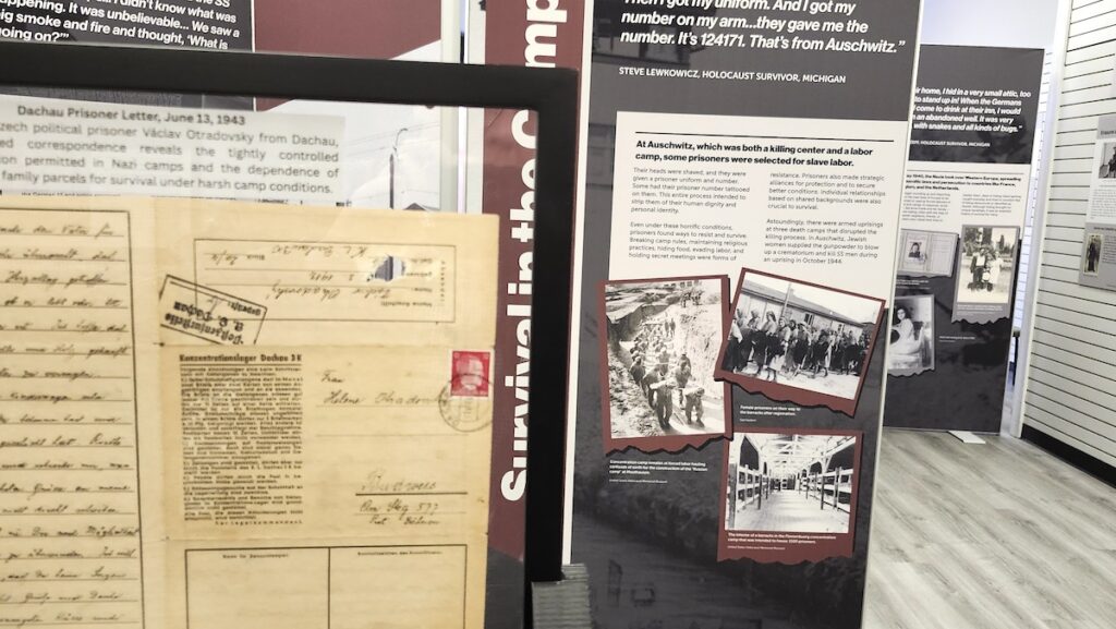 In the foreground of this image is a letter from a political prisoner at the Dachau concentration camp. Letters from inmates came from the collection of Michael Lehr, and Ron Chinn designed the rotating displays that allow visitors to see both sides of the paper. In the background are exhibit panels from the Zekelman Holocaust Center.