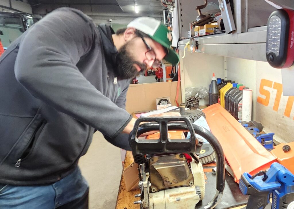 Jeff Talbot works on diagnosing a problem with a customer’s chainsaw at Bill’s Service in Blissfield.