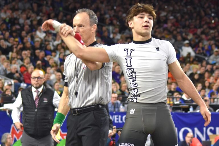 Hudson’s Nicholas Sorrow stands with his hand raised in victory on March 7 at Ford Field. (Photo courtesy of MHSAA)