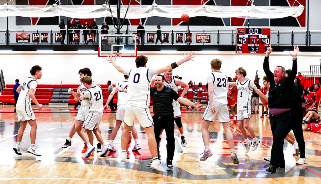Onsted’s Cole Wells, center, celebrates with head coach Brad Maska after the Wildcats’ 42-40 victory over Ecorse in the regional final. (Photo by Erik Tjolsen)