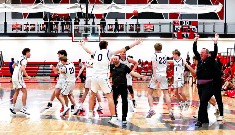 Onsted’s Cole Wells, center, celebrates with head coach Brad Maska after the Wildcats’ 42-40 victory over Ecorse in the regional final. (Photo by Erik Tjolsen)
