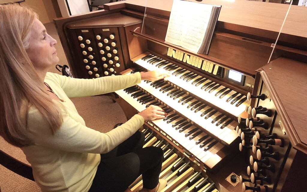 Laura Langley, the organist at First United Methodist Church in Adrian, demonstrates the operation of church’s pipe organ, which recently underwent a major restoration. The church, located at 1245 W. Maple Ave., will celebrate and rededicate the organ with a concert at 4 p.m. Sunday, May 24. (Photo by Erik Gable)
