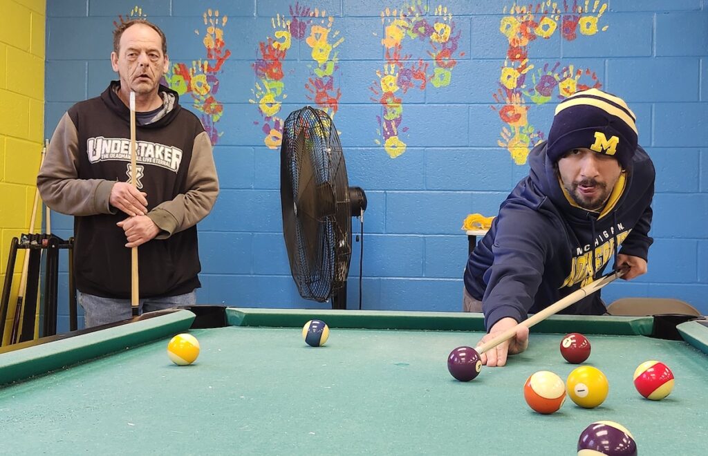 Jacob Tripp and Bryan Hoag play a game of pool at the HOPE Community Center in Adrian. (Photo by Erik Gable)